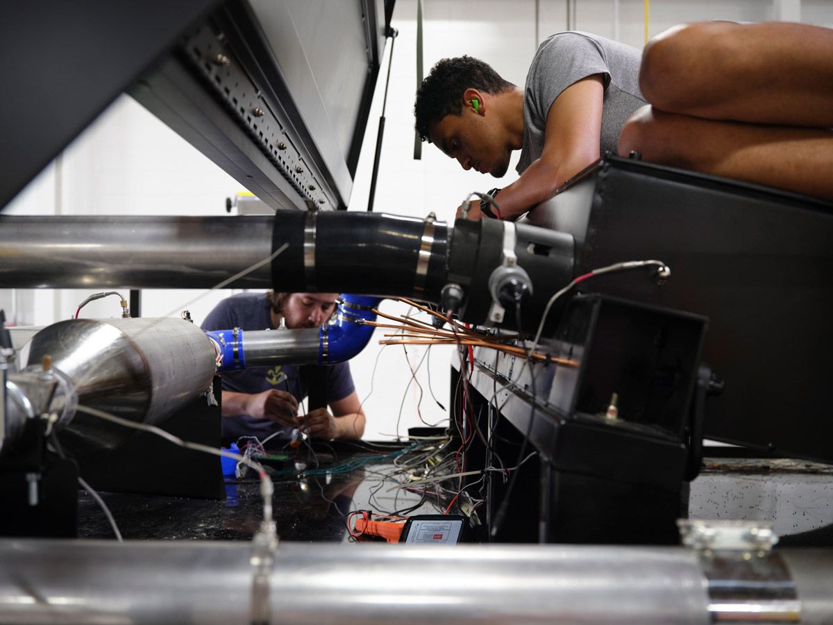 Two men installing the solution on a semitrailer cab. 